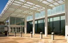 A modern hospital building with a glass entrance and columns.