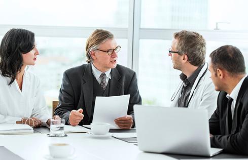 Businesspeople and doctors around a table