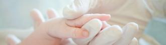 Baby hand held by a nurse