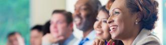 Smiling people sit at a table at work